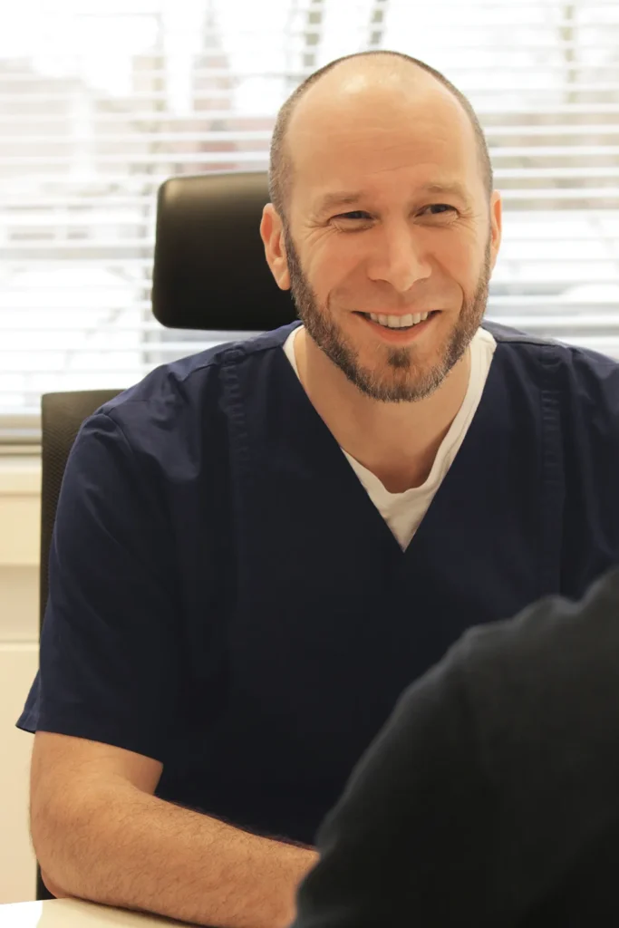 Portrait des Arztes und Gastroenterologen Björn Lesniak, im Patientengespräch in der Sprechstunde.
